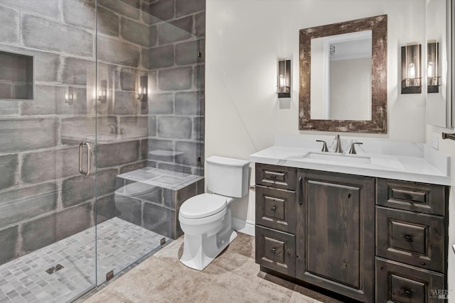 bathroom featuring toilet, a stall shower, and vanity
