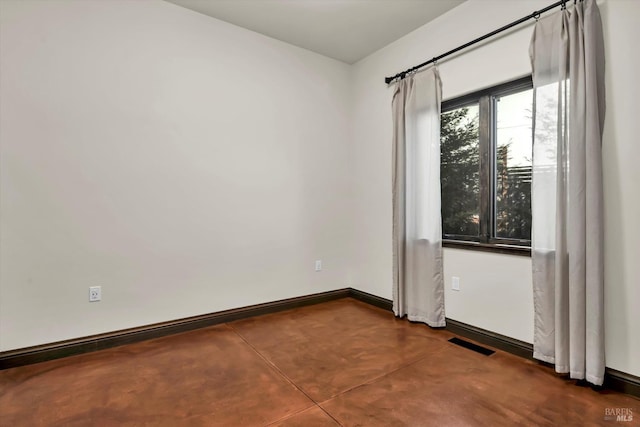unfurnished room featuring visible vents, baseboards, and finished concrete floors