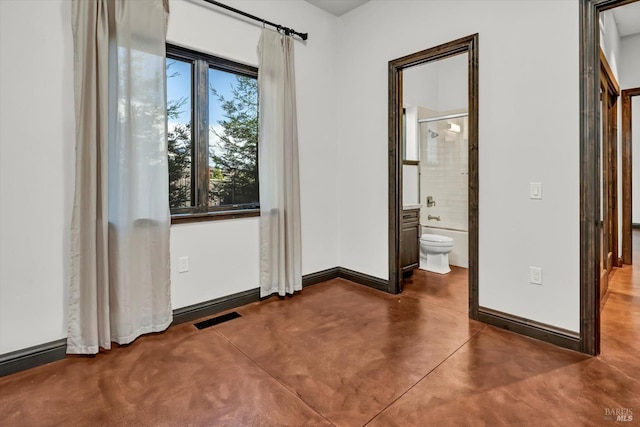 empty room featuring finished concrete flooring, baseboards, and visible vents