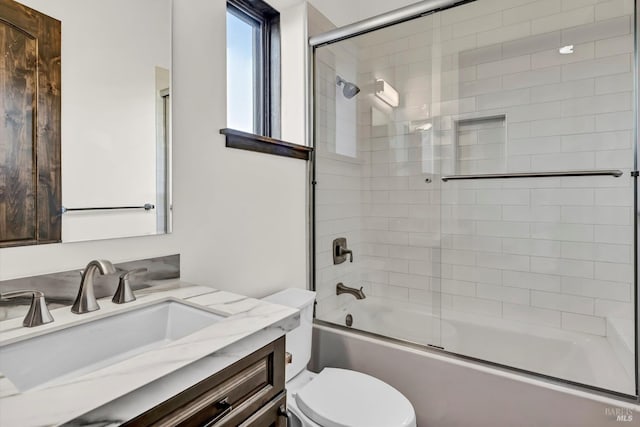 full bath with shower / bath combination with glass door, vanity, and toilet
