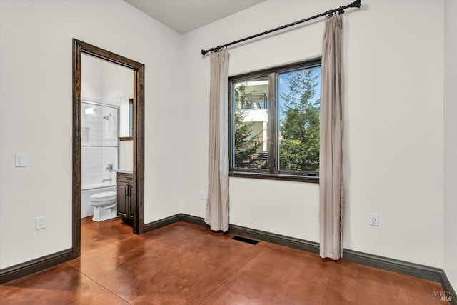 interior space featuring finished concrete flooring, baseboards, visible vents, and connected bathroom