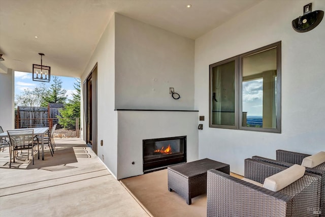 view of patio / terrace featuring outdoor dining area and a glass covered fireplace