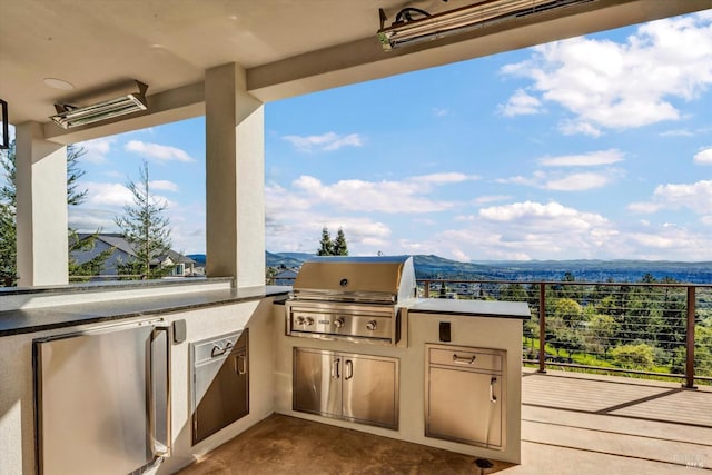 view of patio / terrace featuring a mountain view, a grill, and exterior kitchen