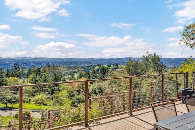 balcony featuring a wooded view and a mountain view