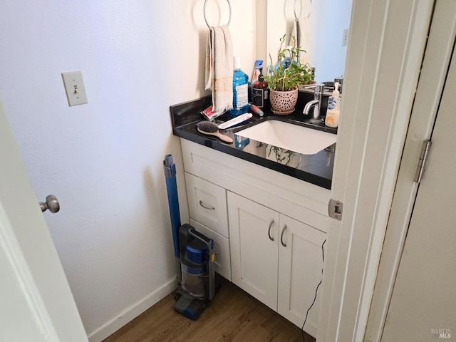 bathroom with wood finished floors, vanity, and baseboards