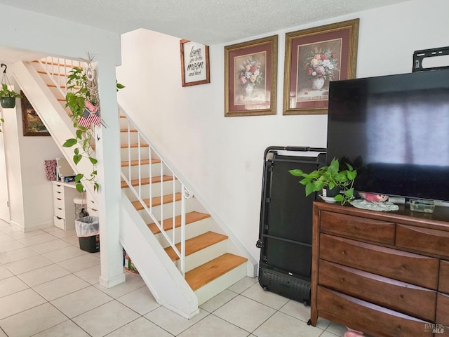 stairs with tile patterned floors and a textured ceiling