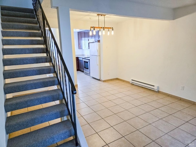 stairway featuring tile patterned floors, baseboard heating, and baseboards