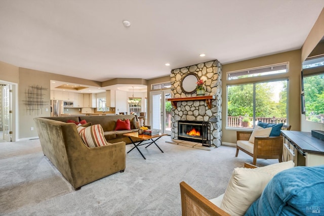 living area with light carpet, a stone fireplace, and baseboards