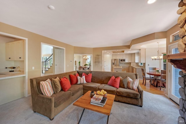 living area featuring recessed lighting, stairway, an inviting chandelier, and light carpet