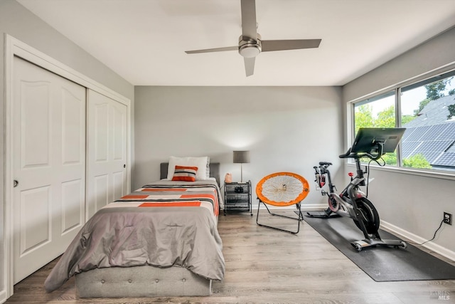 bedroom featuring a closet, ceiling fan, baseboards, and wood finished floors
