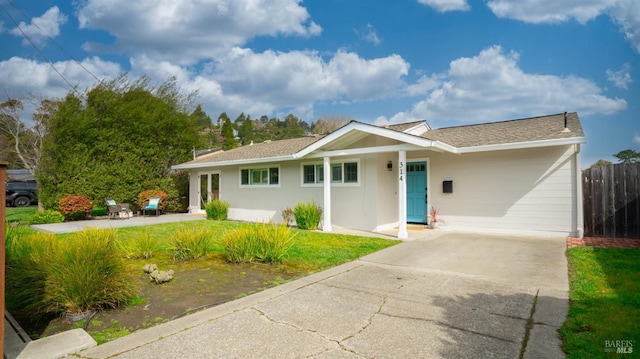 ranch-style house with a patio, driveway, a front lawn, and fence
