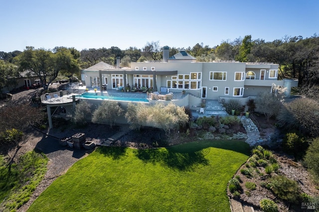 back of house featuring an outdoor pool, stucco siding, a yard, and a patio area