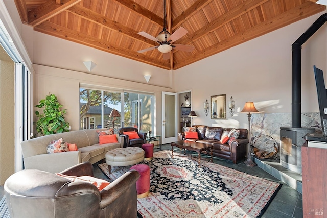tiled living room featuring ceiling fan, wooden ceiling, a wood stove, and a towering ceiling