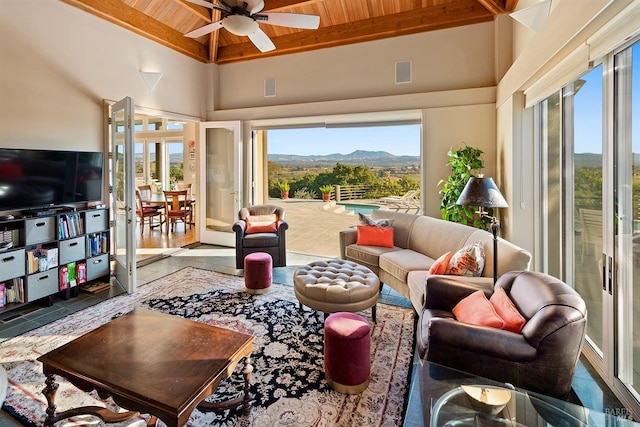 living room with visible vents, wooden ceiling, a towering ceiling, a mountain view, and a ceiling fan