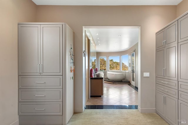hallway featuring light tile patterned floors and baseboards