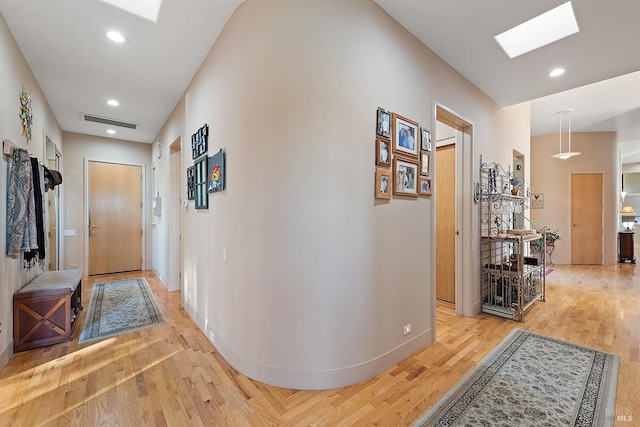 corridor with visible vents, baseboards, a skylight, recessed lighting, and light wood-style floors