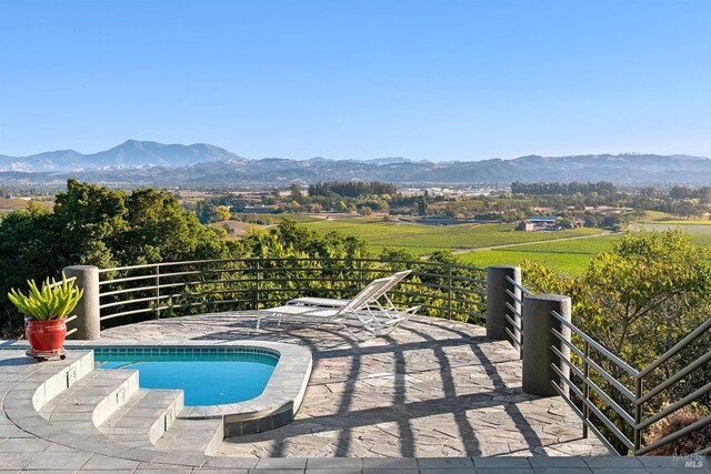 view of swimming pool featuring a rural view and a mountain view