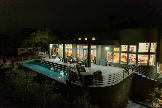 pool at twilight featuring an outdoor pool and a patio