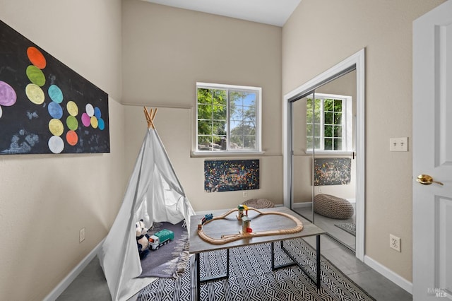 recreation room featuring tile patterned floors and baseboards