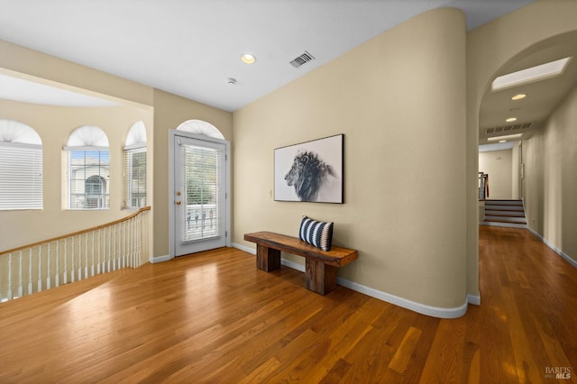 foyer entrance featuring baseboards, wood finished floors, visible vents, and recessed lighting