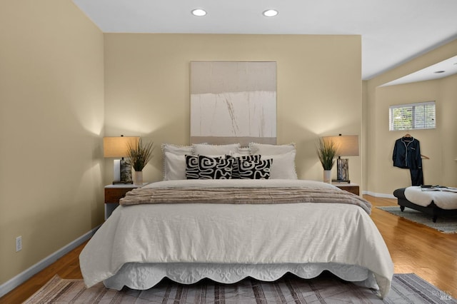 bedroom with wood finished floors, baseboards, and recessed lighting