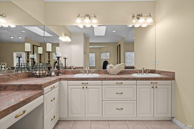 bathroom with tile patterned flooring, a sink, and double vanity
