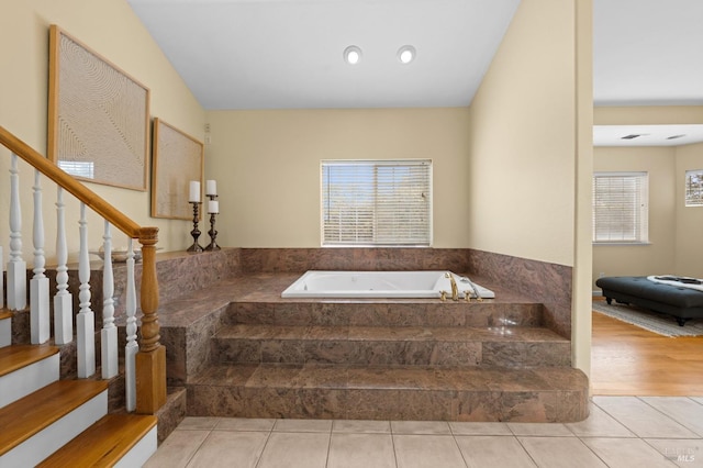 full bathroom featuring a bath and tile patterned flooring