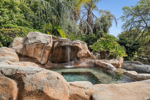 exterior details with a garden pond