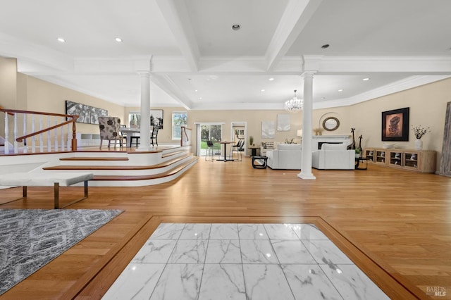 foyer featuring stairs, ornate columns, and ornamental molding