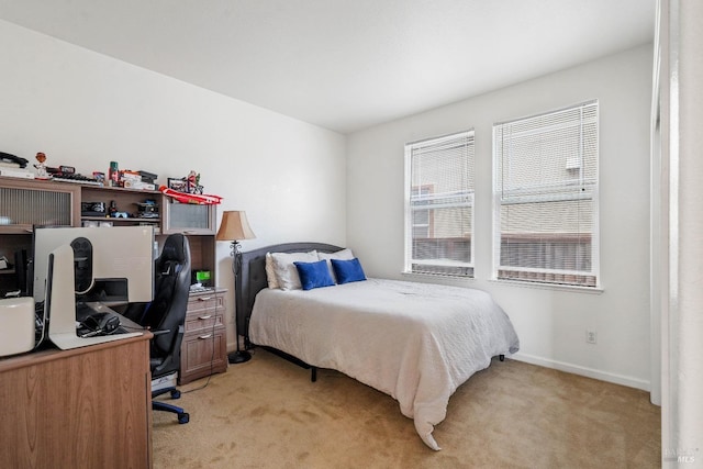 bedroom featuring light colored carpet and baseboards