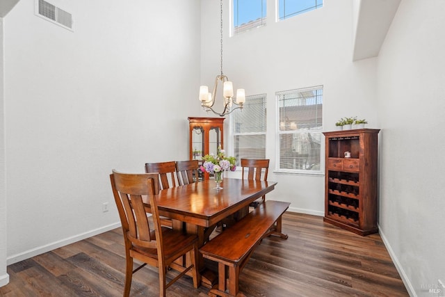 dining space featuring an inviting chandelier, baseboards, visible vents, and dark wood-style flooring