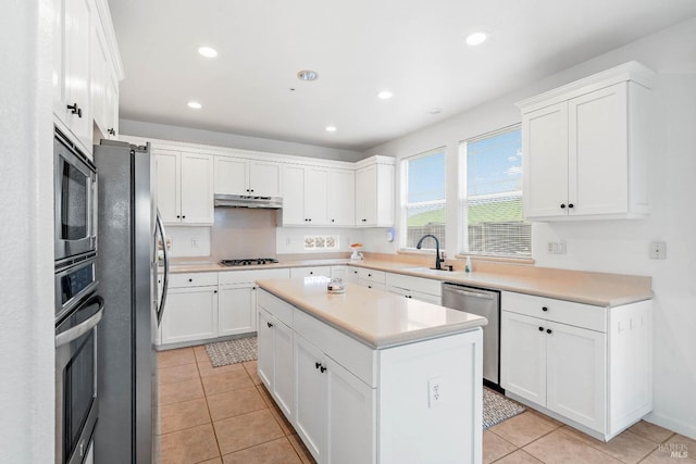 kitchen with a sink, white cabinets, under cabinet range hood, and stainless steel appliances