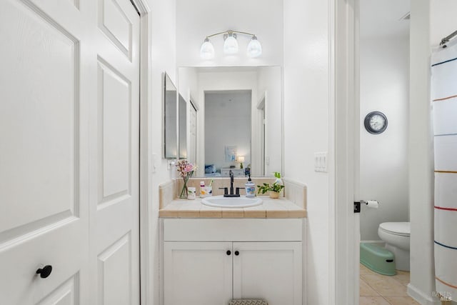 full bathroom featuring ensuite bathroom, toilet, vanity, and tile patterned flooring