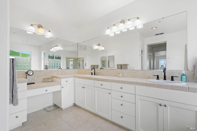 full bath featuring tile patterned floors, visible vents, decorative backsplash, and a sink