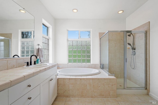 full bath featuring vanity, a garden tub, a stall shower, and tile patterned flooring