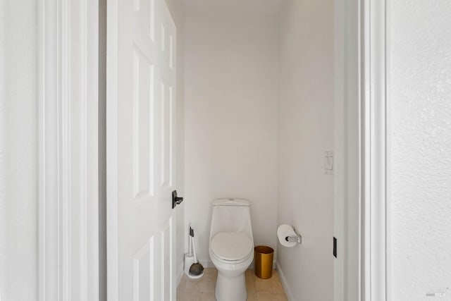 bathroom featuring baseboards, toilet, and tile patterned flooring
