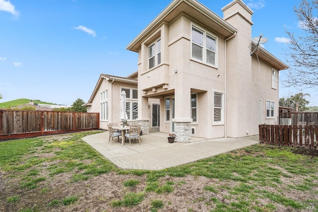 rear view of house featuring a patio area, stucco siding, a lawn, and a fenced backyard