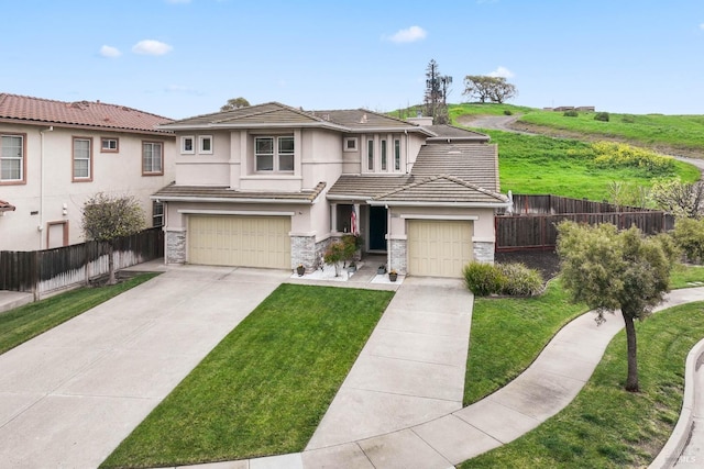 prairie-style home with stucco siding, stone siding, concrete driveway, and fence
