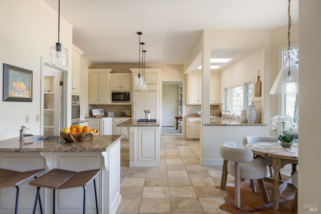 1706 Garnett Creek Ct, Calistoga, CA 94515 - kitchen with appliances with stainless steel finishes, a kitchen island, cream cabinetry, decorative backsplash, and a sink