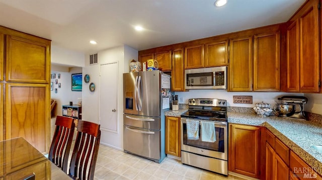 kitchen featuring recessed lighting, brown cabinets, and stainless steel appliances