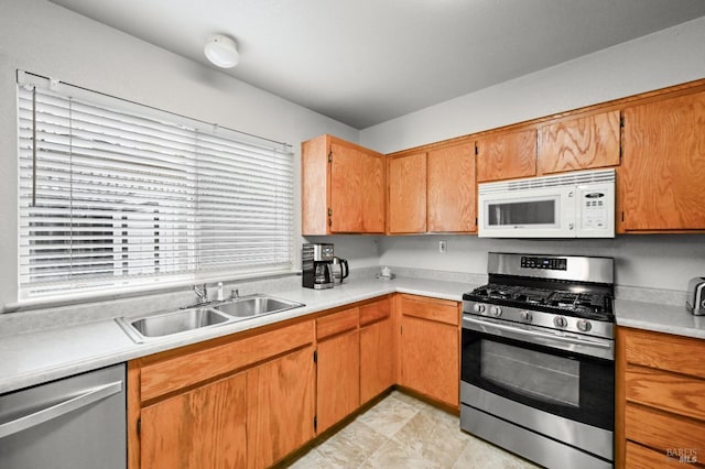 kitchen featuring stainless steel appliances, light countertops, and a sink