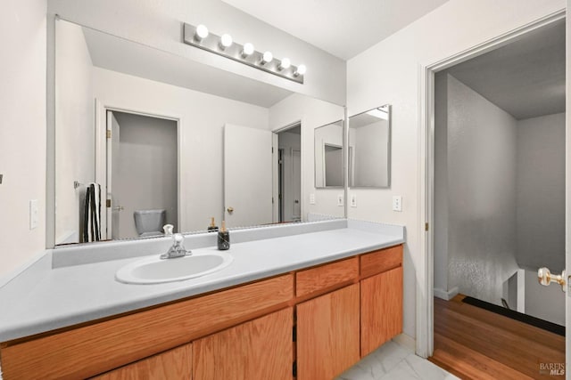 bathroom with vanity, toilet, and marble finish floor