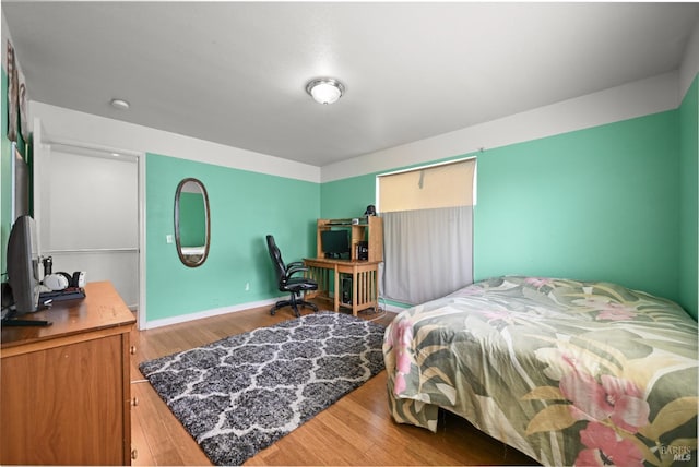 bedroom with baseboards and wood finished floors