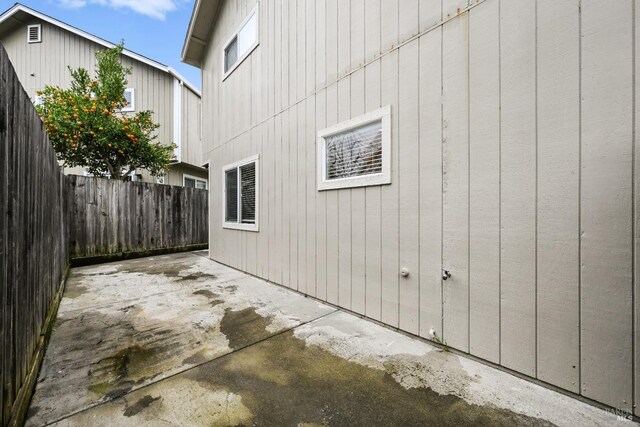 view of home's exterior with a patio area and fence