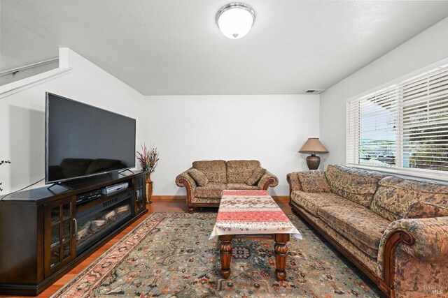 living room with visible vents, baseboards, and wood finished floors