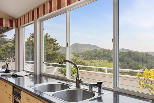 kitchen with a mountain view, a sink, and dark countertops