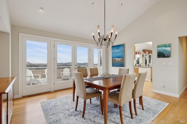 dining room featuring baseboards, light wood-type flooring, a chandelier, recessed lighting, and vaulted ceiling