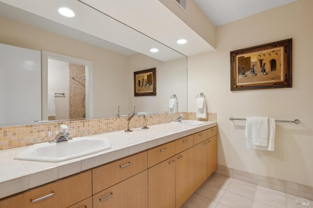 bathroom with a sink, visible vents, double vanity, and tile patterned flooring