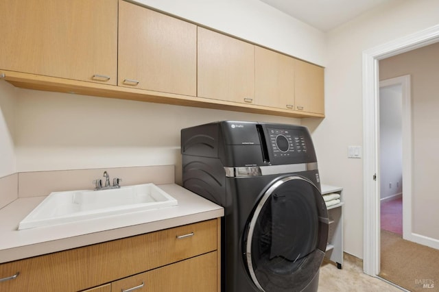 clothes washing area with cabinet space, washer / clothes dryer, light carpet, and a sink