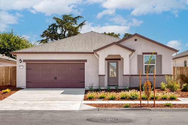 view of front of home with concrete driveway, stucco siding, fence, an attached garage, and a shingled roof